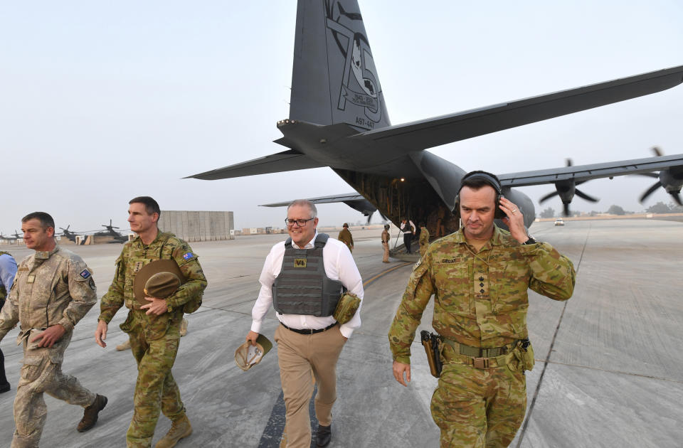 Australian Prime Minister Scott Morrison, center, is seen during a visit to Task Group Taji at Taji Military Complex in Iraq, Wednesday, Dec. 19, 2018. Prime Minister Morrison has made a pre-Christmas visit to hundreds of troops in Iraq, telling them he wanted to say thank you from "one Australian to another."(David Mariuz/AAP Image via AP)