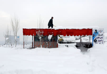 An Afghan man removes snow from his shop on the outskirts of Kabul, Afghanistan February 5, 2017.REUTERS/Omar Sobhani