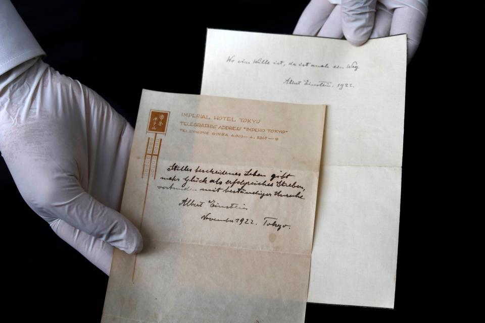 Gal Wiener, owner and manager of the Winner's auction house in Jerusalem, displays two notes written by Albert Einstein (Photo: MENAHEM KAHANA via Getty Images)