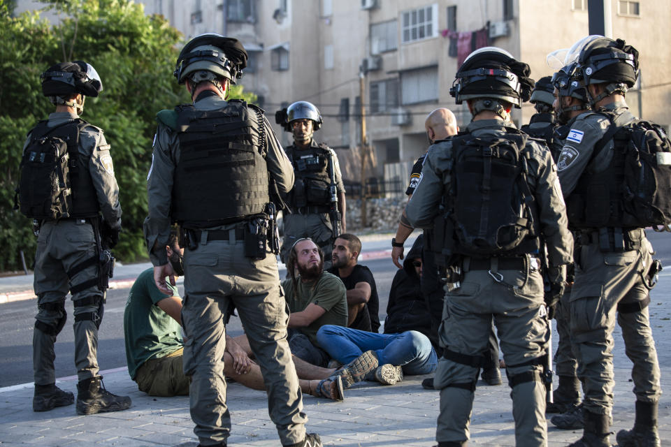 Israeli paramilitary border police detain Jewish settlers, during clashes between Arabs, police and Jews, in the mixed town of Lod, central Israel, Wednesday, May 12, 2021. As rockets from Gaza streaked overhead, Arabs and Jews fought each other on the streets below. Rioters torched vehicles, a restaurant and a synagogue in one of the worst spasms of communal violence that Israel has seen in years. (AP Photo/Heidi Levine)