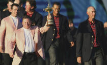 FILE - Ian Woosnam, the European Ryder Cup team captain holds the trophy as he leads his team from the stage with his U.S. counterpart Tom Lehman after his team beat the United States to win the 2006 Ryder Cup at the K Club golf course, Straffan, Ireland, Sunday Sept. 24, 2006. The Americans last won a Ryder Cup in Europe in 1993.(AP Photo/Peter Morrison, File)