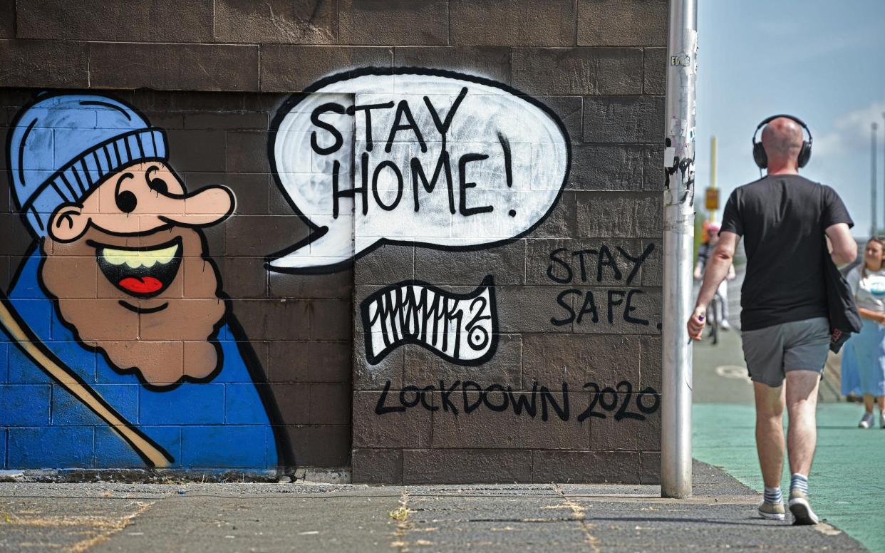 A man walks past graffiti on Clyde Street on May 27, 2020 in Glasgow, - Getty Images