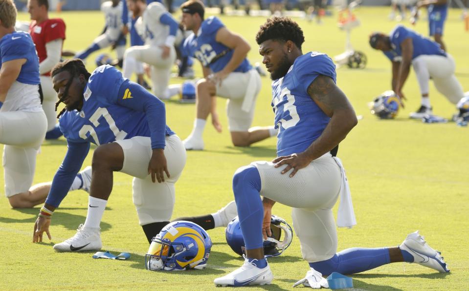 Rams running back Cam Akers stretches with running back Darrell Henderson Jr.