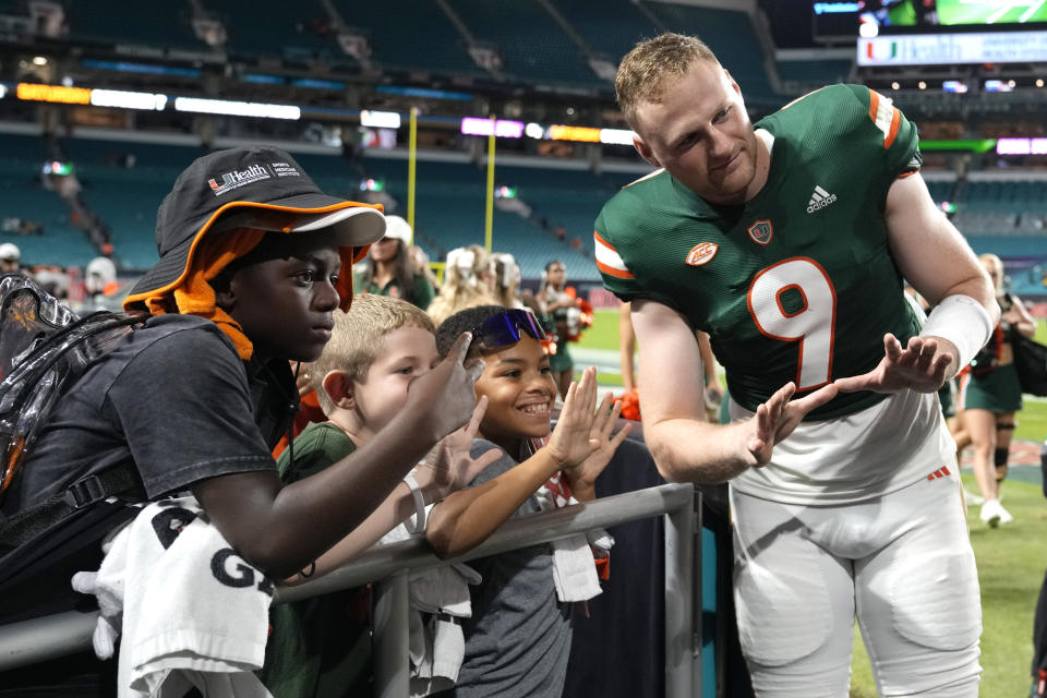 Miami quarterback Tyler Van Dyke (9) poses with fans after the team's NCAA college football game against Bethune-Cookman on Thursday, Sept. 14, 2023, in Miami Gardens, Fla. (AP Photo/Lynne Sladky)