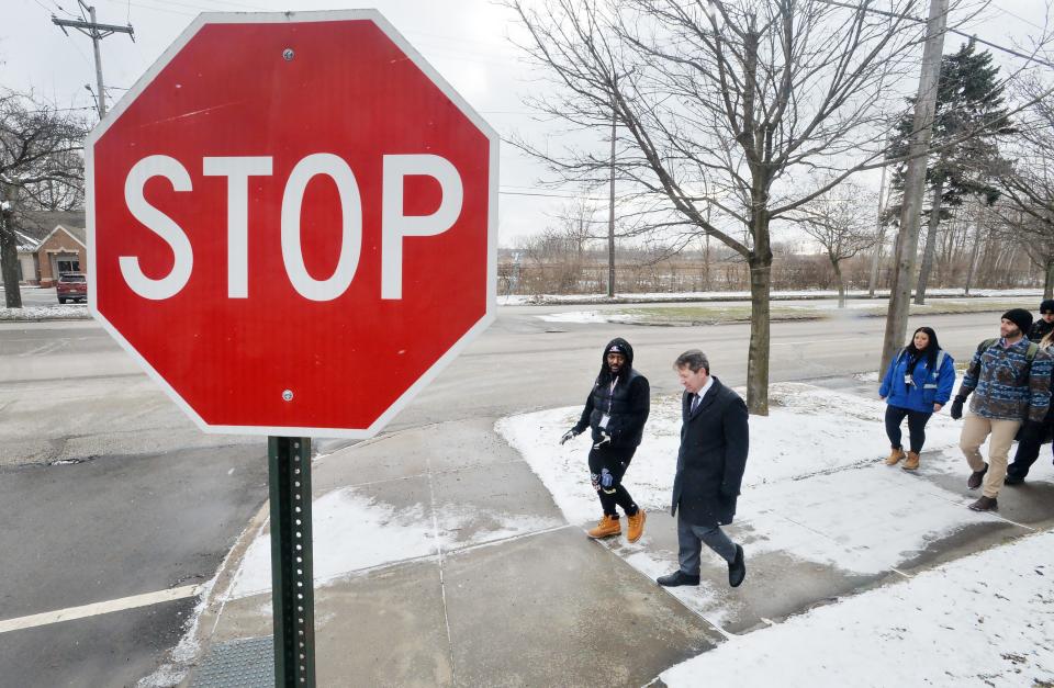 Blue Coats member Roscoe Carroll, center left, joins Erie School District Superintendent Brian Polito and others to highlight the need for safe walking routes for students as they walk along East Lake Road on Tuesday.