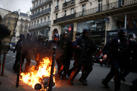 French riot police run in a street during clashes with protesters wearing yellow vests during a national day of protest by the "yellow vests" movement in Paris, France, December 8, 2018. REUTERS/Stephane Mahe