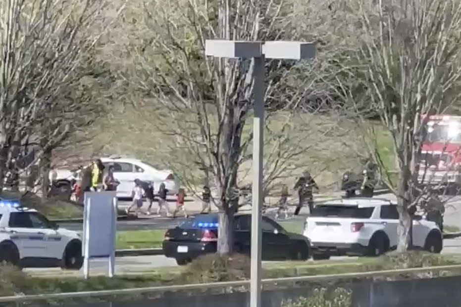 Law enforcement officers lead children away from the scene of a shooting at The Covenant School, a private Christian school in Nashville, Tenn., on Monday March, 27, 2023. Source: Jozen Reodica via AP