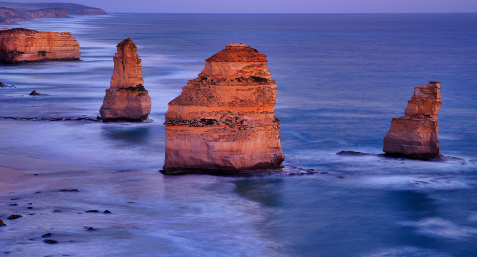 The Twelve Apostles in low light, likely sunset.