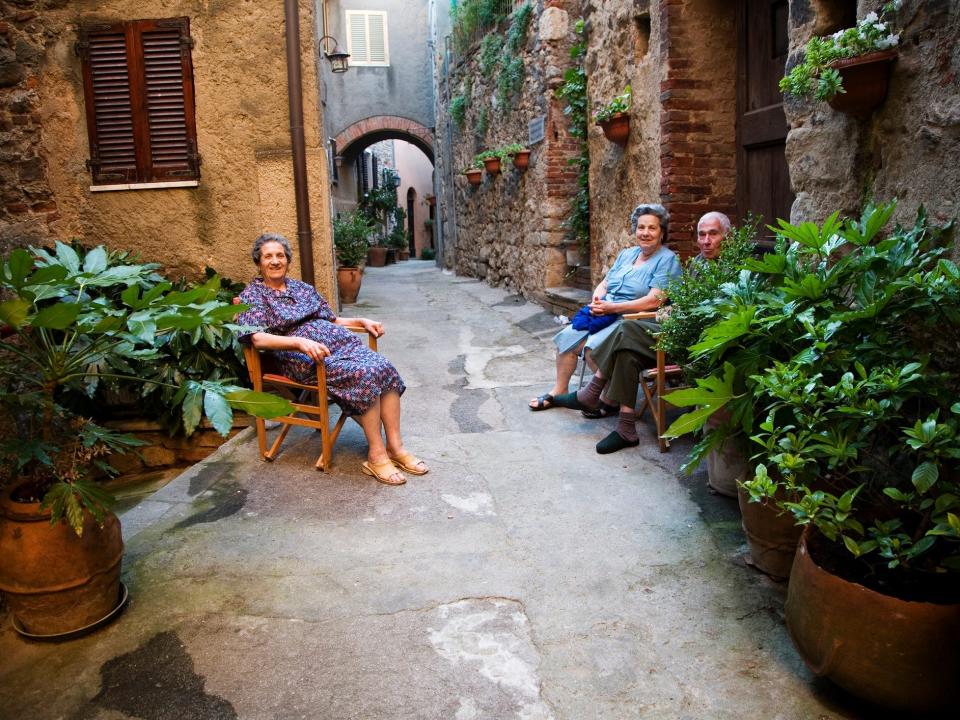 Seniors sitting in the street chatting in Italy