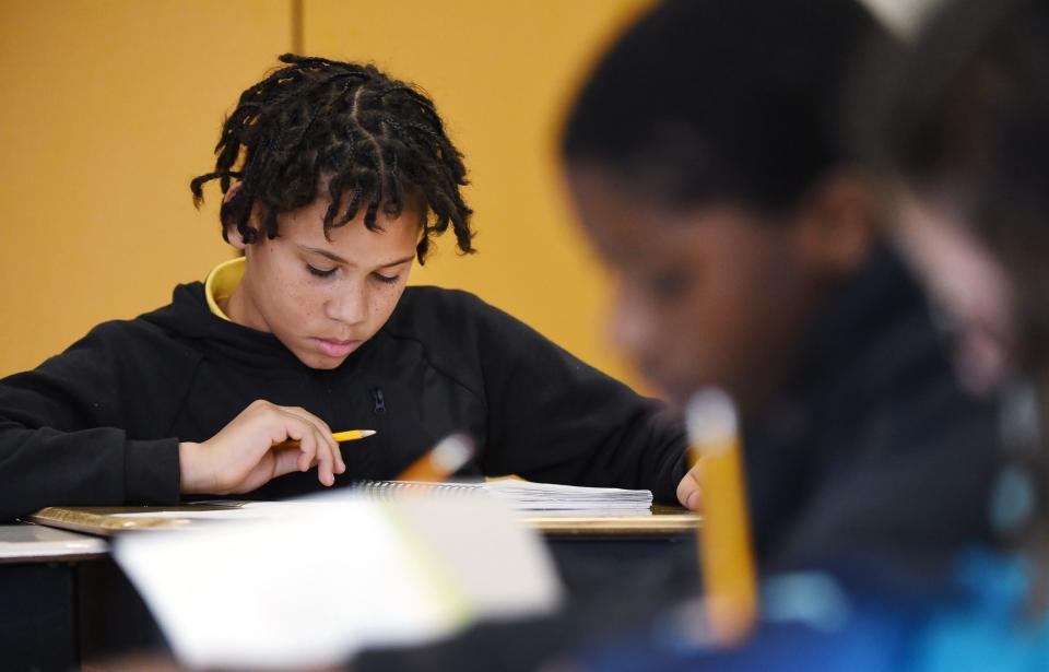 Pfeiffer-Burleigh Elementary School fifth-grader Christian Rivera, 10, left, takes a test with classmates in Erie.