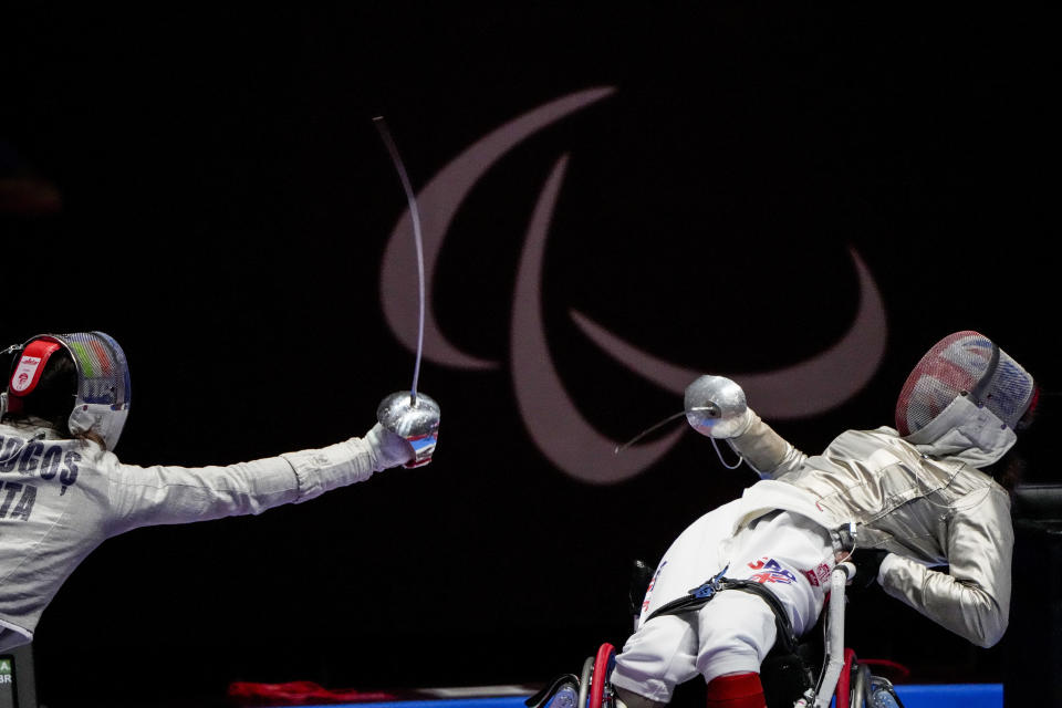 FILE - In this Aug. 25, 2021 file photo, Britain's Gemma Collins-McCann, right, defends against Italy's Ionela Andreea Mogos in women's saber individual, category A preliminary wheelchair fencing at the Tokyo 2020 Paralympic Games in Chiba, Japan. There are 4,403 Paralympic athletes competing in Tokyo, each with unique differences that have to be classified. Lines have to be draw, in the quest for fairness, to group similar impairments, or impairments that yield similar results. (AP Photo/Kiichiro Sato, File)