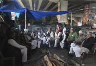 Indian Farmers hold a meeting under a flyover as they continue to block a highway leading to Delhi in protest against new farm laws, at Delhi-Uttar Pradesh border, India, Friday, Jan. 22, 2021. Talks between protesting farmers’ leaders and the government ended abruptly in a stalemate on Friday with the agriculture minister saying he has nothing more to offer than suspending contentious agricultural laws for 18 months. The farmers’ organizations in a statement on Thursday said they can’t accept anything except the repeal of the three new laws. (AP Photo/Manish Swarup)