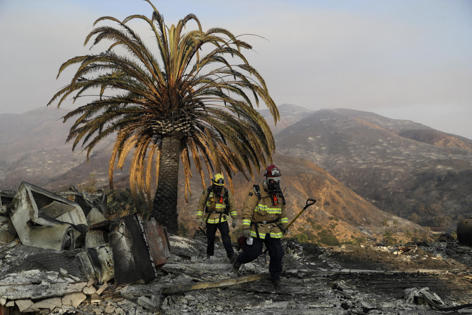 Firefighters Jason Toole, right, and Brent McGill with the Santa Barbara Fire Department&nbsp;walk among the ashes of a wildfire-ravaged home after turning off an open gas line on the property Saturday, Nov. 10, 2018, in Malibu, Calif.&nbsp; (Photo: ASSOCIATED PRESS)