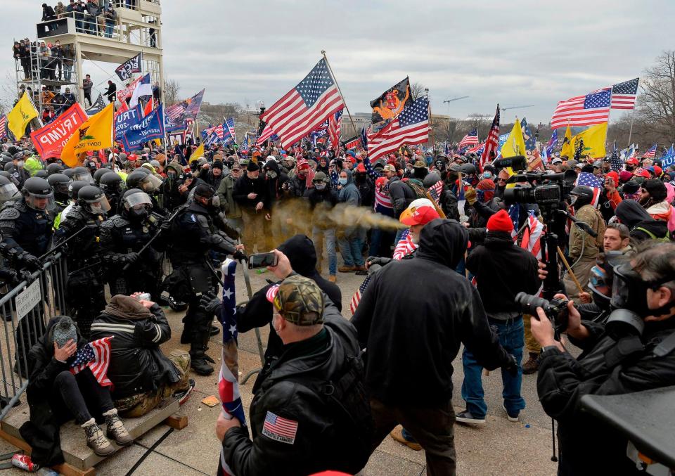 Trump supporters clash with police and security forces as they try to storm the US Capitol surrounded by tear gas in Washington, DC on January 6, 2021.