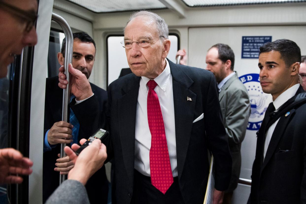 Republican Sen. Chuck Grassley takes questions from congressional reporters while standing in the doorway of an automated Senate subway train in April 2019.