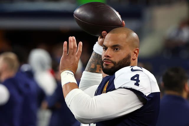 <p>Richard Rodriguez/Getty</p> Dak Prescott #4 of the Dallas Cowboys warms up on the sidelines during a game against the Washington Commanders at AT&T Stadium on November 23, 2023 in Arlington, Texas.