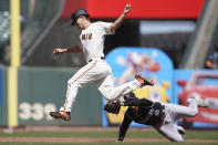 San Francisco Giants' Alex Dickerson, top, is tagged out by Colorado Rockies third baseman Josh Fuentes while trying to advance to third base during the third inning of a baseball game in San Francisco, Saturday, April 10, 2021. (AP Photo/Jeff Chiu)