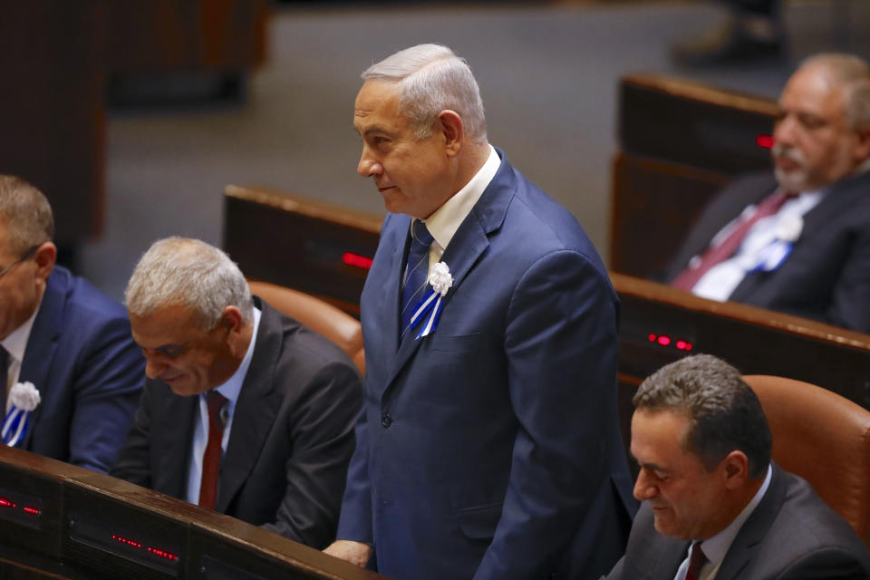 Israeli Prime Minister Benjamin Netanyahu, center, stands during swearing in ceremony at the Knesset, Israel's parliament in Jerusalem, Tuesday, April 30, 2019. Members of Israel's parliament are being sworn in at the Knesset, the country's legislature, three weeks after a tumultuous national election. (AP Photo/Ariel Schalit)