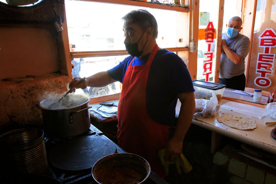 Jaime Meraz stirs a pot at one of Juárez's oldest burrito spots, El Centenario, on Wednesday.