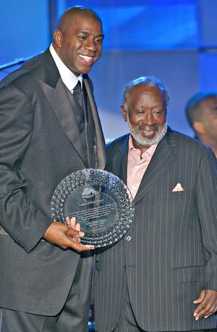 <p>Amanda Edwards/Getty</p> Magic Johnson and Clarence Avant