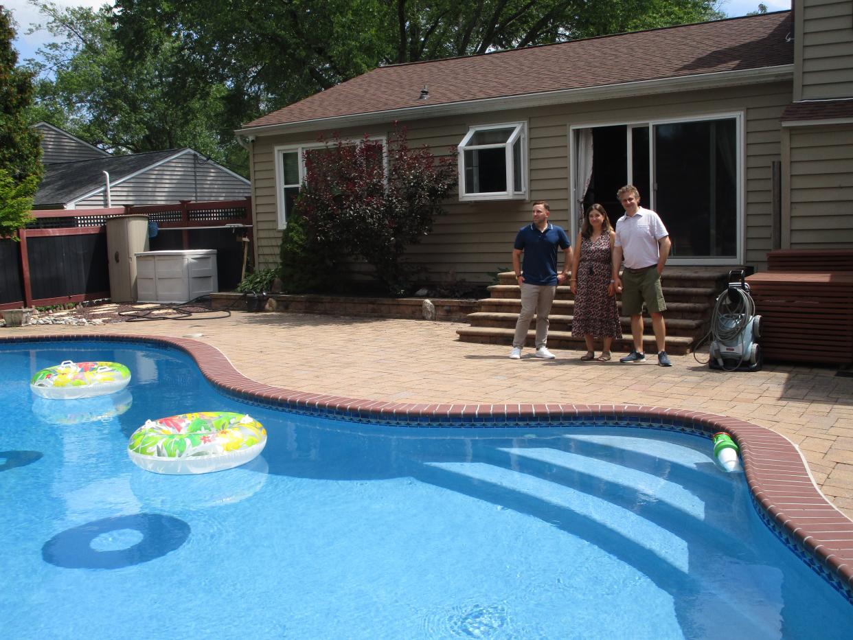 Homebuyers Hilary Levine, center, and Brian Sanders, right, tour the backyard of a Yardley home with real estate agent, Andrew Jacobs, as seen on season 244 of HGTV's House Hunters.