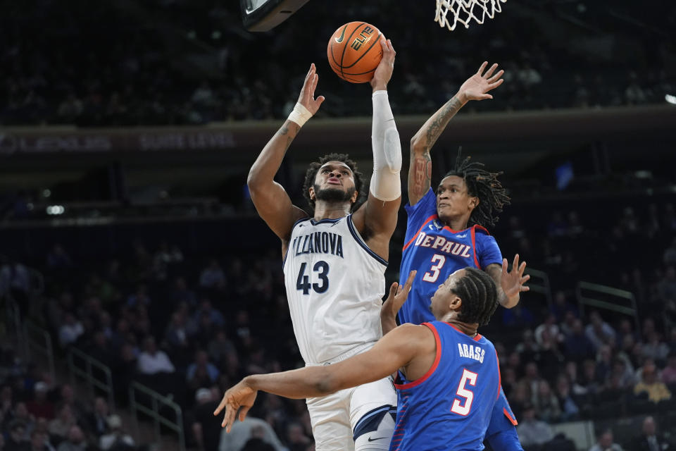 Villanova forward Eric Dixon (43) goes to the basket against DePaul center Churchill Abass (5) and guard Jalen Terry (3) during the first half of an NCAA college basketball game in the first round of the Big East Conference men's tournament Wednesday, March 13, 2024, in New York. (AP Photo/Mary Altaffer)