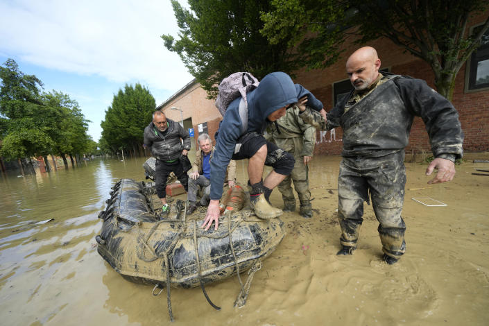 People are rescued in Faenza, Italy, Thursday, May 18, 2023. Exceptional rains Wednesday in a drought-struck region of northern Italy swelled rivers over their banks, killing at least nine people, forcing the evacuation of thousands and prompting officials to warn that Italy needs a national plan to combat climate change-induced flooding. (AP Photo/Luca Bruno)