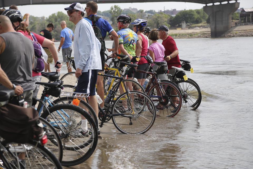 From 2013: Bicyclists dip their wheels in the Missouri River in Council Bluffs on Saturday near the Bob Kerrey Pedestrian Bridge for the start of RAGBRAI XLI.