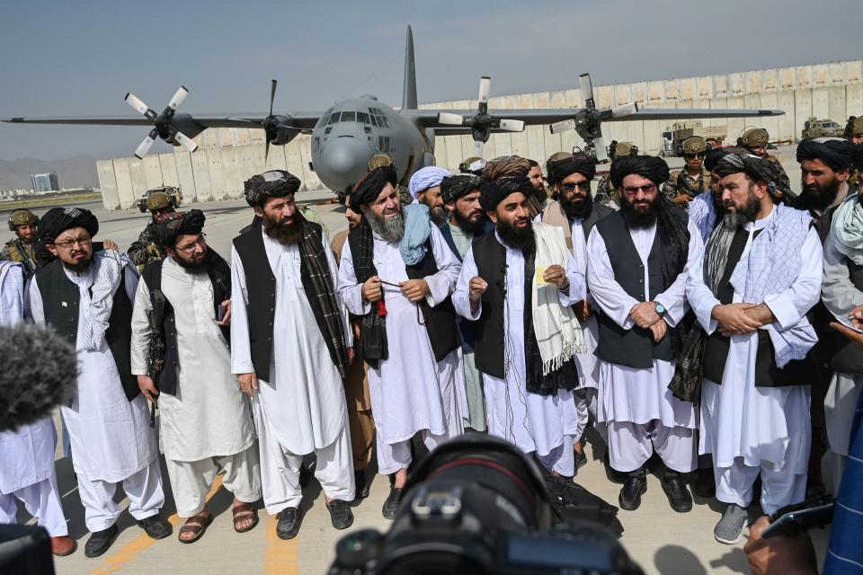 <p>Los líderes talibanes escenificaban su triunfo paseándose por la misma pista en la que unos días antes miles de personas esperaban a ser sacadas del país. El momento fue televisado en directo en Afganistán. (Foto: Wakil Kohsar / AFP / Getty Images).</p> 