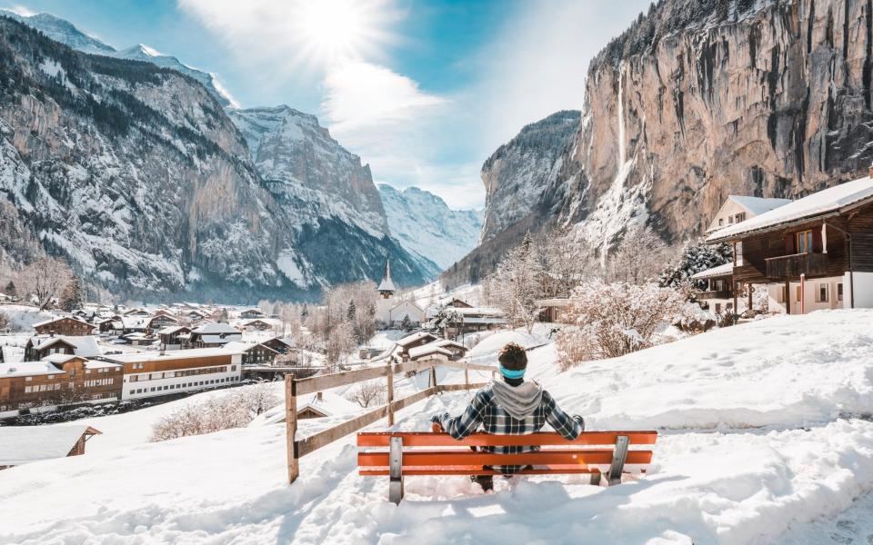 Man admiring Lauterbrunnen in winter, Switzerland - Getty