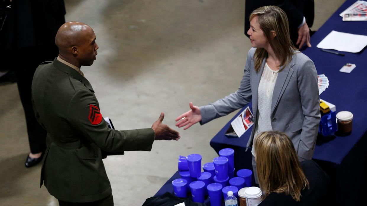 A U.S. Marine shakes hands at an employers booth at the Hiring Our Heroes job fair