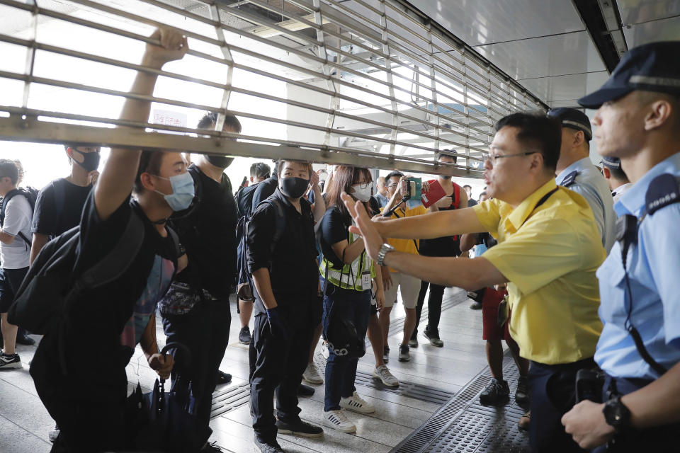 Demonstrators argue with station staff and police at the entrance gate at the Kwun Tong MTR station in Hong Kong, Saturday, Aug. 24, 2019. Chinese police said Saturday they released an employee at the British Consulate in Hong Kong as the city's pro-democracy protesters took to the streets again, this time to call for the removal of "smart lampposts" that raised fears of stepped-up surveillance. (AP Photo/Kin Cheung)