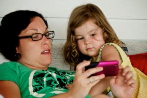 Kid being introduced to an iPhone