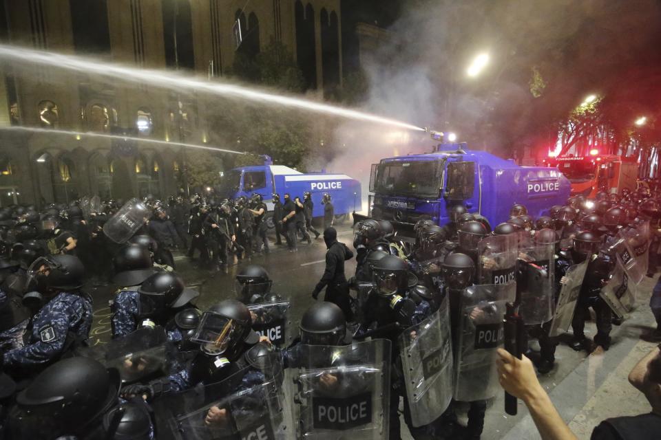 Riot police use a water cannon during an opposition protest against "the Russian law" near the Parliament building in Tbilisi, Georgia, Tuesday night, April 30, 2024. Clashes erupted between police and opposition demonstrators protesting a new bill intended to track foreign influence that the opposition denounced as Russia-inspired. (AP Photo/Zurab Tsertsvadze)