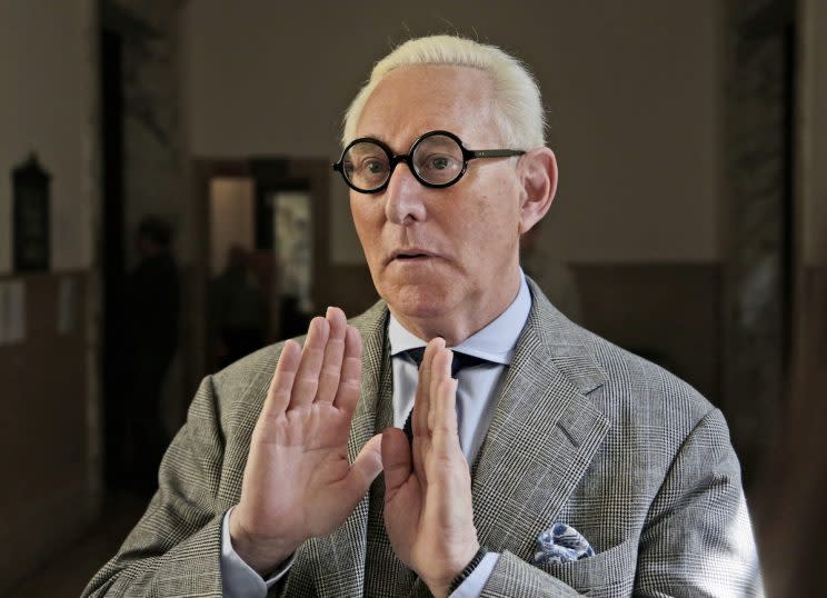 Roger Stone talks to reporters on March 30, wearing the circular, black-framed glasses for which he’s known. (Photo: Seth Wenig/AP)