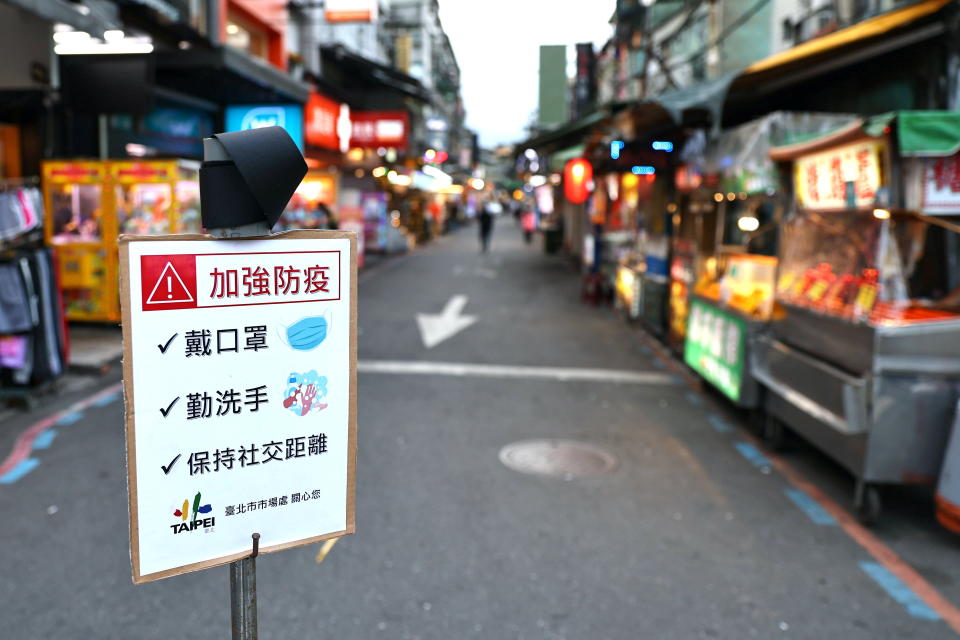 A sign reminding people to wear protective face masks, wash hands and keep social distancing is placed in front of a night market, amid an increasing number of COVID-19 infections, in Taipei, Taiwan, May 15, 2021. REUTERS/Ann Wang