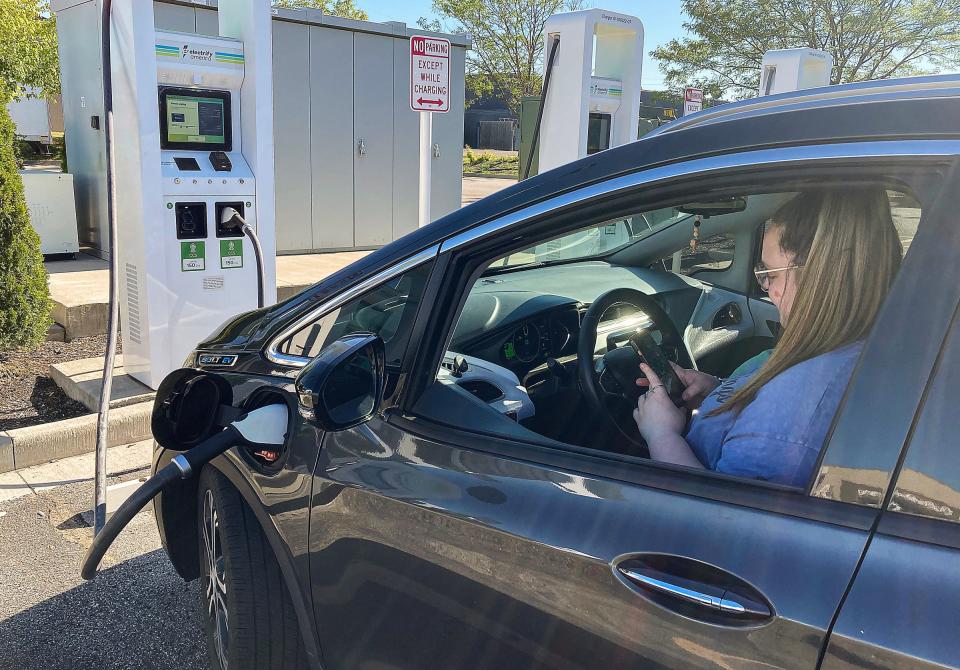 Emma Pate, 22, uses an electric vehicle charging port Thursday, June 23, 2022, on the south side of Indianapolis. Pate has to plan her week around charging her car given the lack of charging stations available in the state, and she said she thinks more drivers would consider EVs if there was better infrastructure. There currently is a federal effort underway to have 500,000 public charging stations for electric vehicles along U.S. highways by 2030.