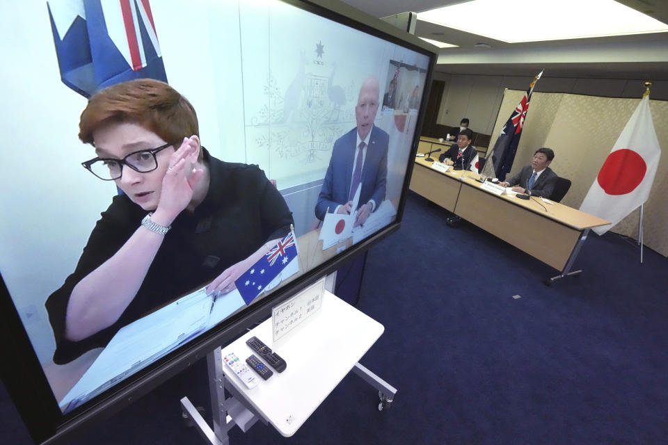 Japanese Foreign Minister Toshimitsu Motegi, right, and Defense Minister Nobuo Kishi, second right, attend a video conference with Australian Foreign Minister Marise Payne, left on screen, and Australian Defense Minister Peter Dutton, right on screen, at Foreign Ministry in Tokyo during their two-plus-two ministerial meeting Wednesday, June 9, 2021, in Tokyo. (AP Photo/Eugene Hoshiko, Pool)