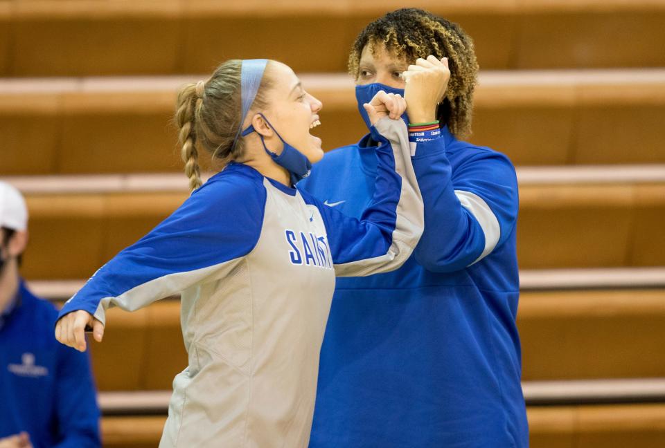 Thomas More Saints assistant coach Sydney Moss bumps elbows with Thomas More Saints guard Taylor Clos on Dec. 31, 2020, in Crestview Hills, Kentucky.