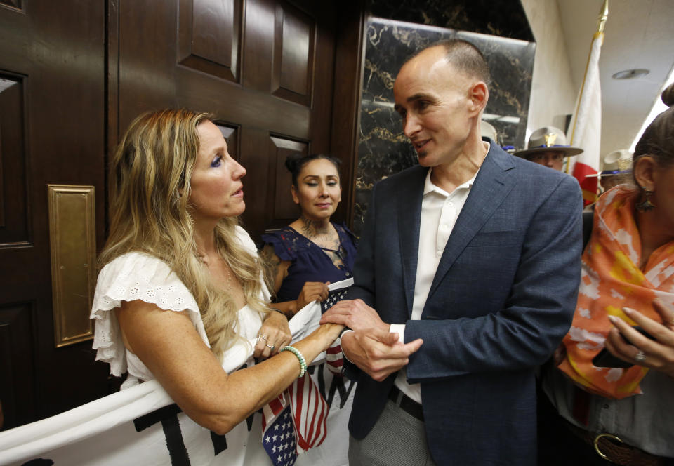 Daniel Zingale, a senior advisor to Gov. Gavin Newsom right, talks with anti-vaccination protester Tara Thornton, as she and others block the door to Gov. Gavin Newsom's office in protest of the state Legislature's passage of a measure to crack down on doctors who sell fraudulent medical exemptions for vaccinations, at the Capitol in Sacramento, Calif., Wednesday, Sept. 4, 2019. Lawmakers sent the bill to Newsom on Wednesday but he said he wants last-minute changes. Zingale met with protesters to hear the issues with the legislation. (AP Photo/Rich Pedroncelli)