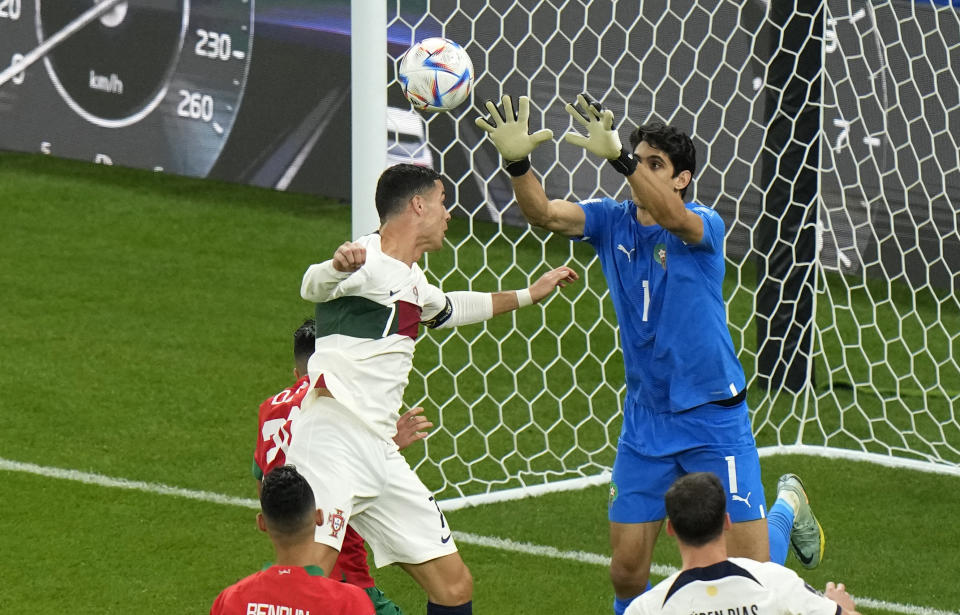 Morocco's goalkeeper Yassine Bounou, right, makes a save in front of Portugal's Cristiano Ronaldo during the World Cup quarterfinal soccer match between Morocco and Portugal, at Al Thumama Stadium in Doha, Qatar, Saturday, Dec. 10, 2022. (AP Photo/Luca Bruno)