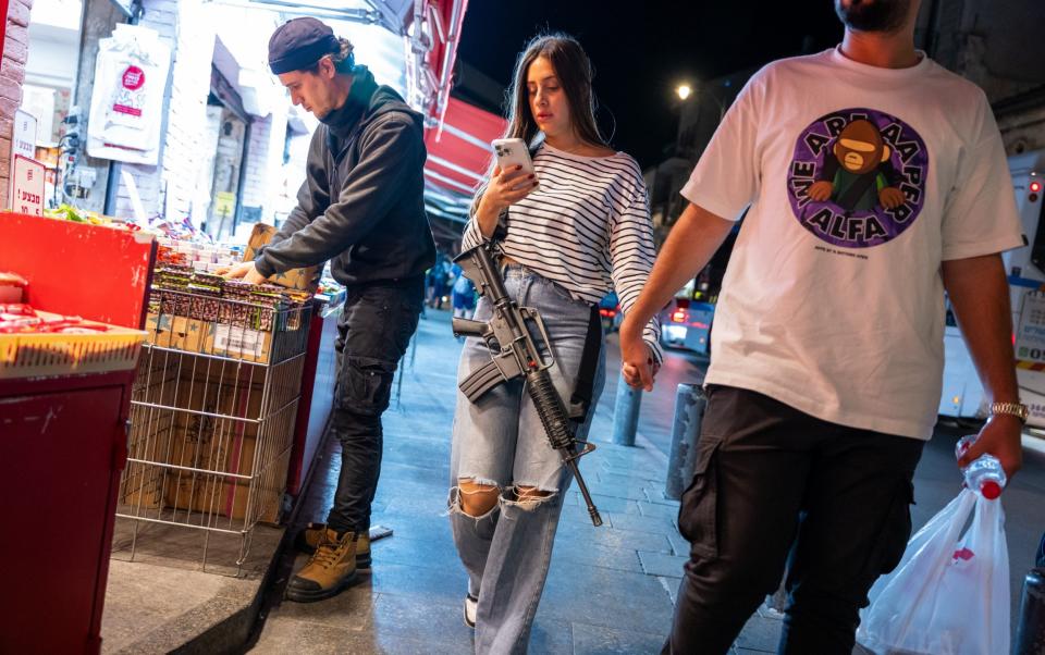 An armed woman walks through Jerusalem