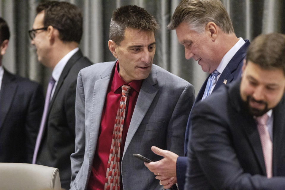 Dallas Woodhouse, executive director of the NC Republican Party, talks with Mark Harris, a Republican candidate in North Carolina's 9th Congressional race, during a break in the third day of a public evidentiary hearing on the 9th Congressional District voting irregularities investigation Wednesday, Feb. 20, 2019, at the North Carolina State Bar in Raleigh, N.C. (Travis Long/The News & Observer via AP)