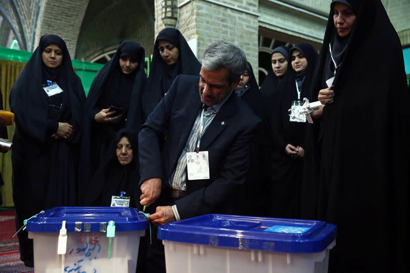 A poll worker opens a ballot box after the parliamentary election voting time ended in Tehran