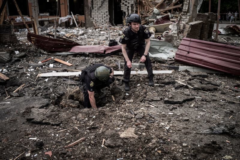 Military inspect a bomb crater between rubble after a bomb hit the residential district of Oleksyvka. Nicolas Cleuet/Le Pictorium via ZUMA Press/dpa