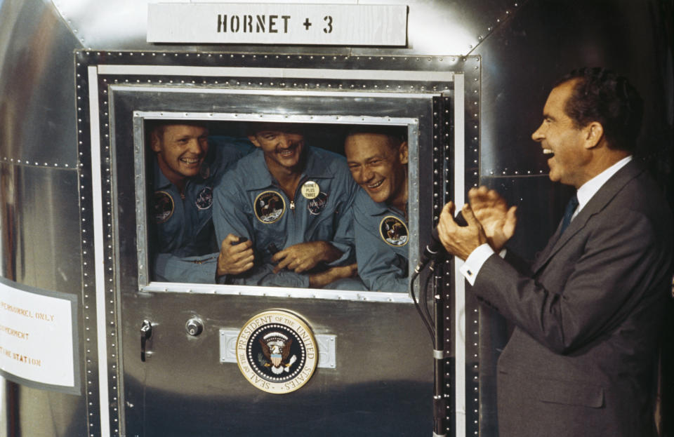 24th July 1969:  From left to right, Neil Armstrong, Michael Collins and Edwin 'Buzz' Aldrin Jnr, the crew of the historic Apollo 11 moon landing mission are subjected to a period of quarantine upon their return to earth. Through the window of their Mobile Quarantine Facility, they hold a conversation with President Richard Nixon (1913 - 1994).  (Photo by MPI/Getty Images)