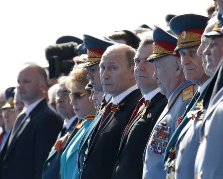 Russian President Vladimir Putin (C) and Prime Minister Dmitry Medvedev (5th R) watch the Victory Day parade in Moscow's Red Square in this May 9, 2014 file photo. REUTERS/Grigory Dukor/Files