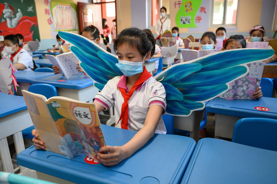 Elementary school students wear wings May 20 to maintain social distancing amid concerns over the spread of COVID-19 in a classroom in Taiyuan in China's northern Shanxi province. 