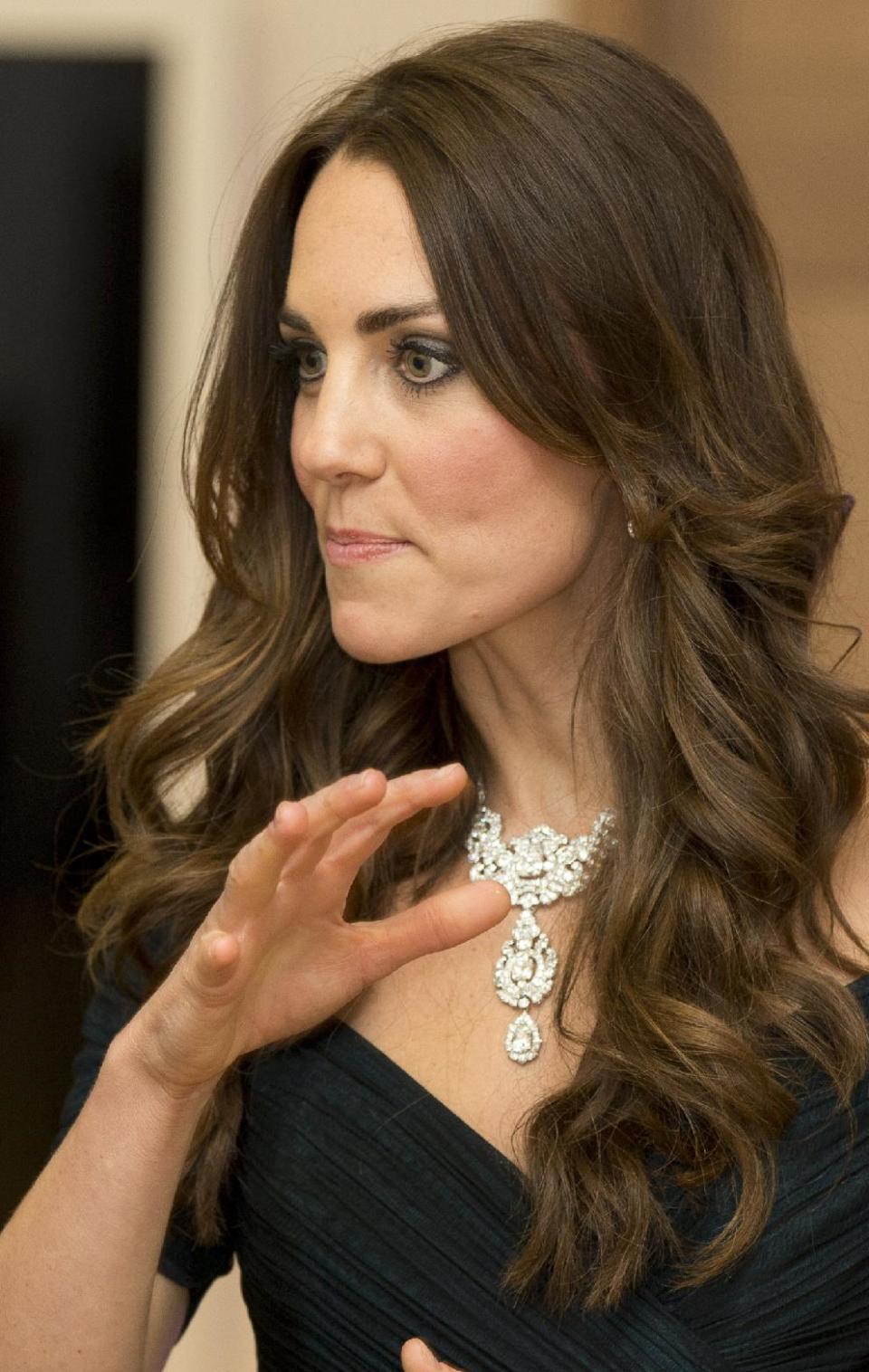 Kate Duchess of Cambridge talks to guests at a fund raising gala at theNational Portrait Gallery in London, Tuesday, Feb. 11, 2014. . The Duchess is wearing a dress by British designer Jenny Packham and a necklace on loan from Queen Elizabeth II that was given to the Queen as a gift for her wedding in 1947. (AP Photo/Alastair Grant, Pool)