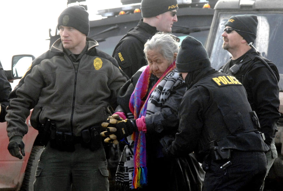 <p>An elderly woman is escorted to a transport van after being arrested by law enforcement at the Oceti Sakowin camp as part of the final sweep of the Dakota Access pipeline protesters in Morton County, Thursday, Feb. 23, 2017, near Cannon Ball, N.D. (Mike McCleary/The Bismarck Tribune via AP, Pool) </p>